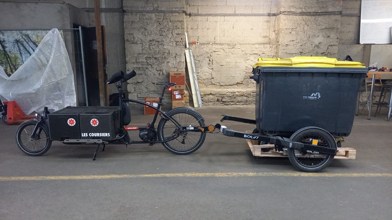 Vélo cargo avec remorque portant une poubelle
